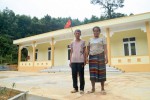 Vợ chồng ông Hồ Văn Trung bên điểm Trường Tiểu học thôn Mít vừa được xây dựng vào năm 2017