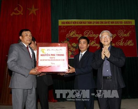 Tổng Bí thư Nguyễn Phú Trọng tặng quà cho Đảng bộ , chính quyền và nhân dân xã nông thôn mới Vĩnh Thủy. Ảnh: TTXVN