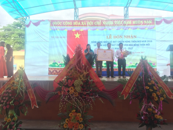 Bà Hồ Thị Lệ Hà trao bằng công nhận “ Xã đạt chuẩn nông thôn mới năm 2016” cho đại diện lãnh đạo xã Tân Long.