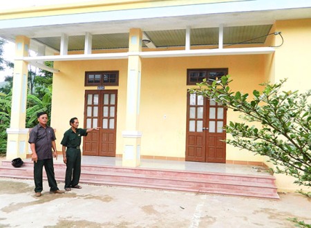 Cựu chiến binh Hồ Văn Trị (phải) bên ngôi trường mình đã hiến đất xây dựng